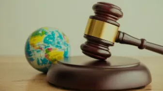 A gavel and a globe on a table.